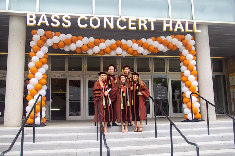 People wearing regalia and smiling.