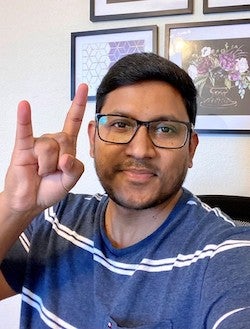 Dr. Maniruzzaman giving the Hook 'em Horns hand gesture.