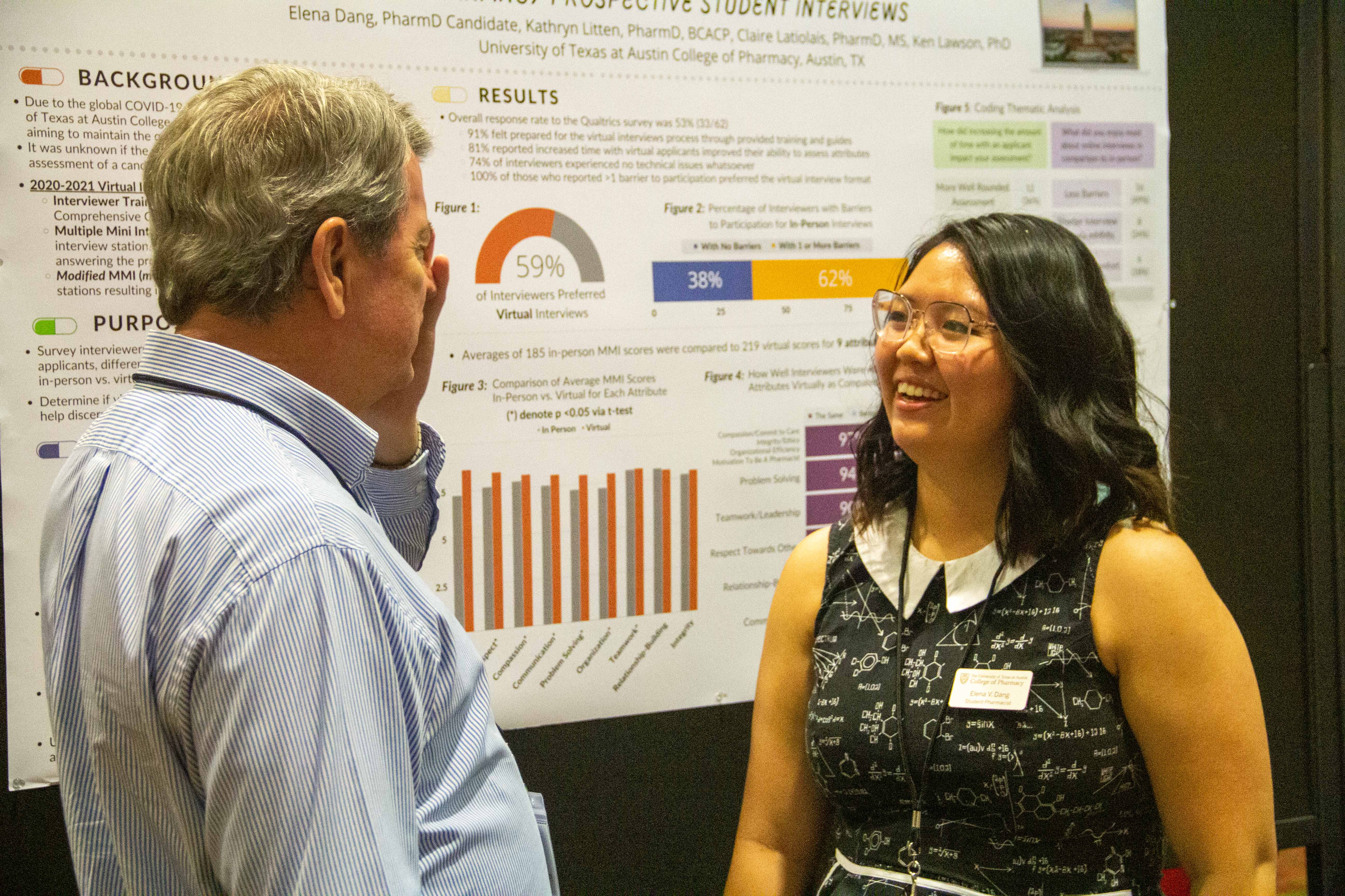 A man and a woman in conversation in front of a scientific poster board.