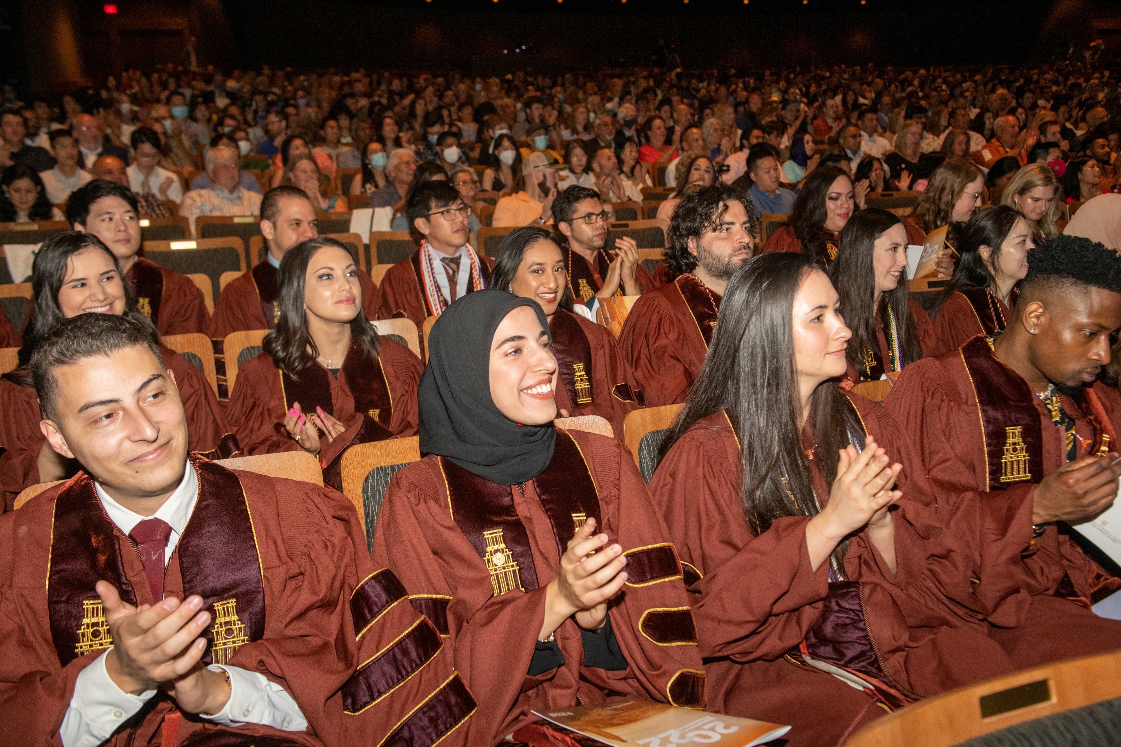 Class of 2022 graduates celebrating in the auditorium.
