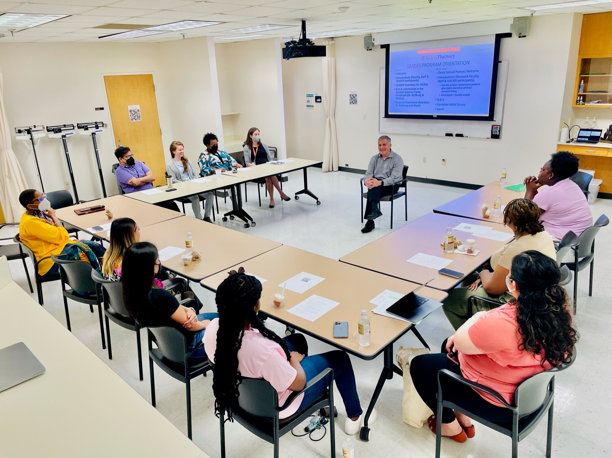 Dean Poloyac sitting with student participants in classroom.