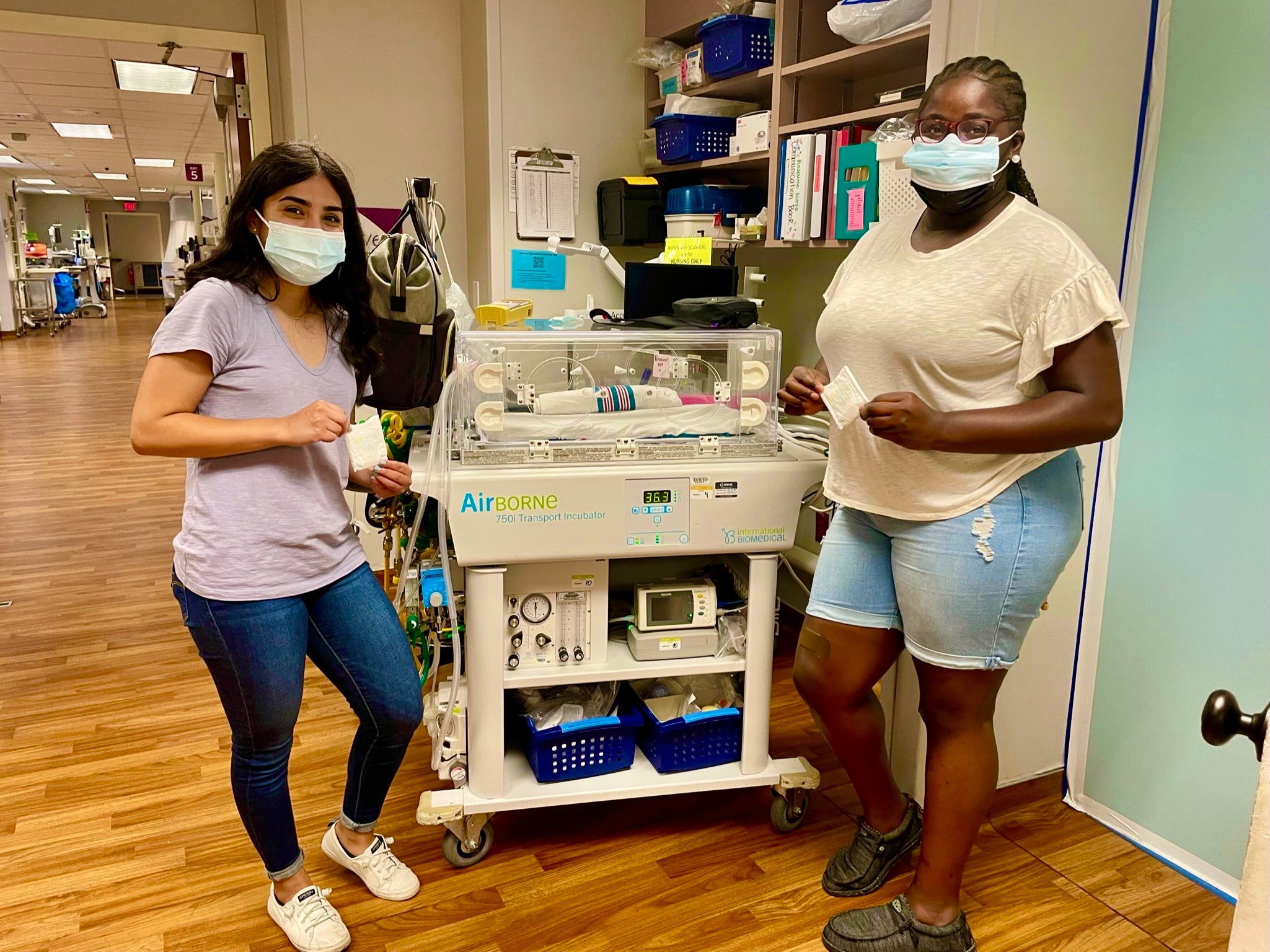 Two students wearing masks, working in the hospital.