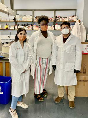 Three LEADER Program participants wearing lab coats in lab