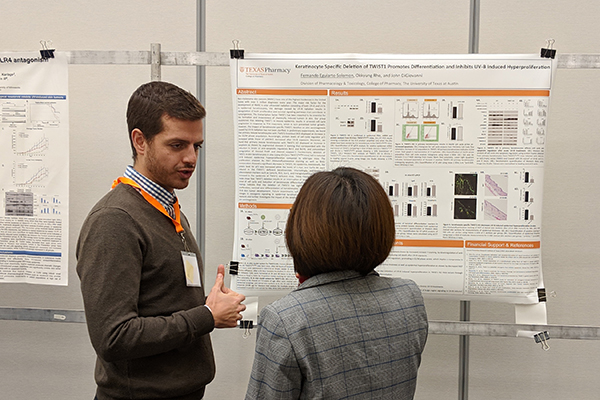 PharmTox graduate student discussing research poster with participant