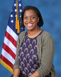 Dr. Shelly Williams seated in front of American flag