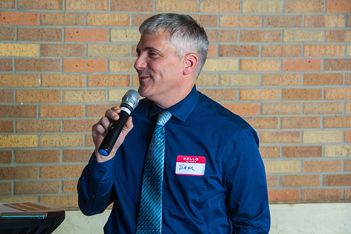 Dean Poloyac holding microphone and speaking at PharmTox Meet and Greet event