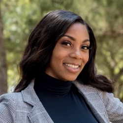 Charity Crockett smiling while wearing a patterned blazer and turtleneck sweater.