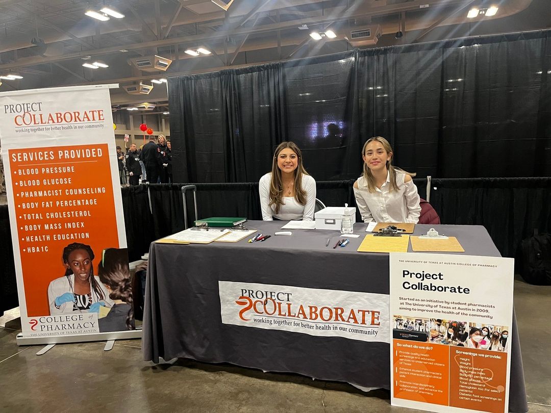 Two Project Collaborate members sitting at a booth.