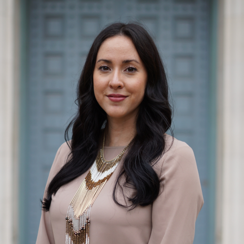 A headshot of Dr. Lindsey J. Loera: Lindsey is smiling and has long brown hair. She is wearing a beige blouse and an intricate beaded necklace.