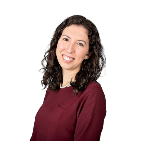 Dr. Ashley Castleberry smiling at camera. She has shoulder-length brown hair and is wearing a maroon blouse.