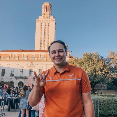 Student Pharmacist, Ryan, wearing an orange shirt and smiling at camera.