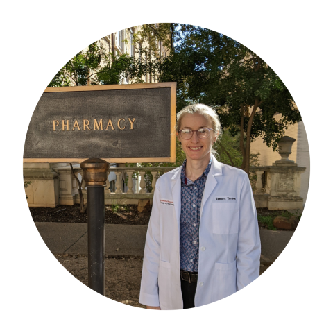 Student Pharmacist Tamara Tarbox standing with the Pharmacy sign on campus.