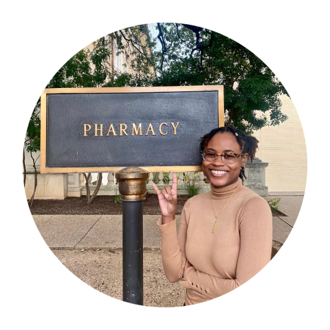Student pharmacist Delandra Robinson standing in front of the Pharmacy sign on campus.