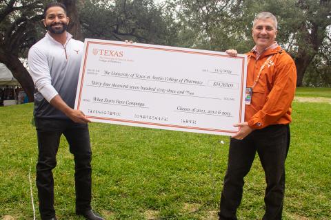 Dr. Jobby John presenting Dean Poloyac with check for The UT Austin College of Pharmacy for $34,763.05 from the Classes of 2011, 2012 and 2013 for the What Starts Here Campaign