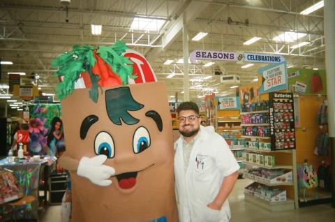 Student Pharmacist Erik Coronado standing with a mascot of a sandwich.