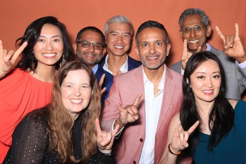 Seven alumni from Class of 2000 giving Hook 'em Horns hand sign in a Photo Booth photo