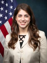 Gaielle Harb smiling in front of an American flag