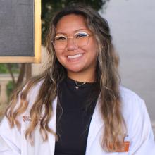 Morgan Losabia smiling in front of the Pharmacy building sign