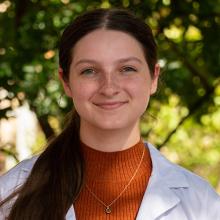 Grace Rosenbaum wearing a white coat in an outdoor setting
