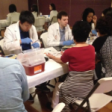 Pharmacy students in white coats working with patients at Korean community Health Screening