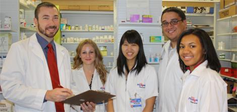 2011 to 2012 residency class group photo with Dr. Pope in pharmacy setting