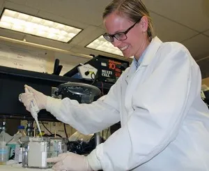 smiling student working in a lab setting