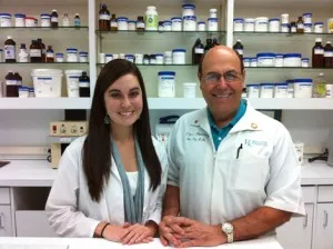 Preceptor and pharmacy student standing at pharmacy counter