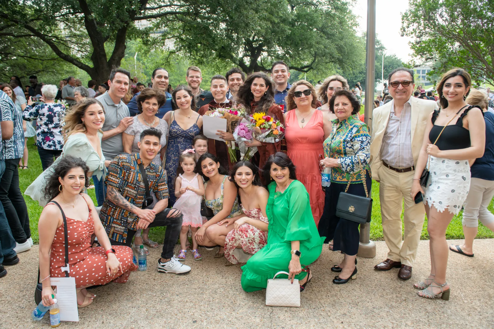 Family posing with recent graduate outside.