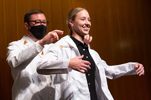 Student receiving white coat at White Coat ceremony