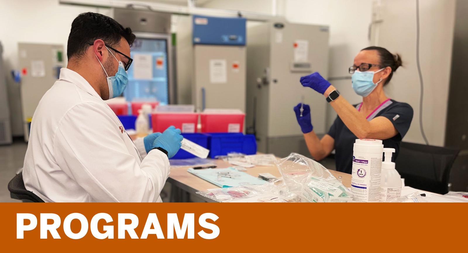 Programs - College of Pharmacy faculty and student preparing vaccines