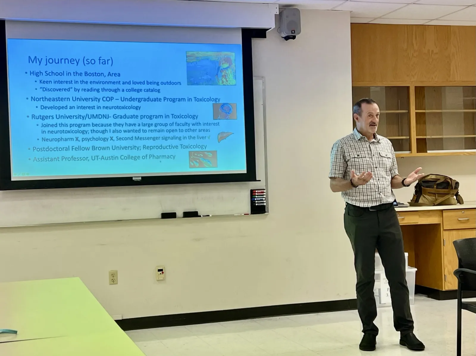 Dr. Richburg lecturing to group in front of a screen.