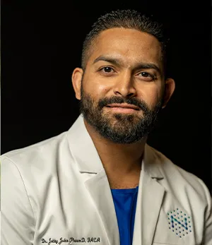 A man wearing a white coat with a t-shirt under it.