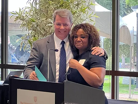 Drs. Ken Lawson and Jamie Barner hugging at podium