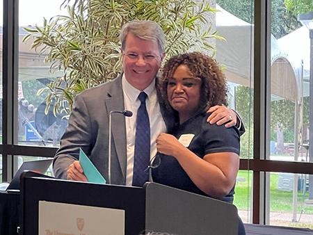 Drs. Ken Lawson and Jamie Barner hugging at podium