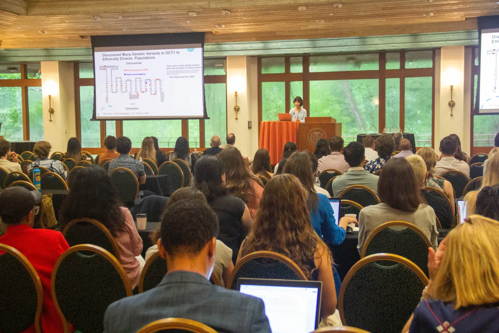 A woman giving a presentation in front of a lot of people.