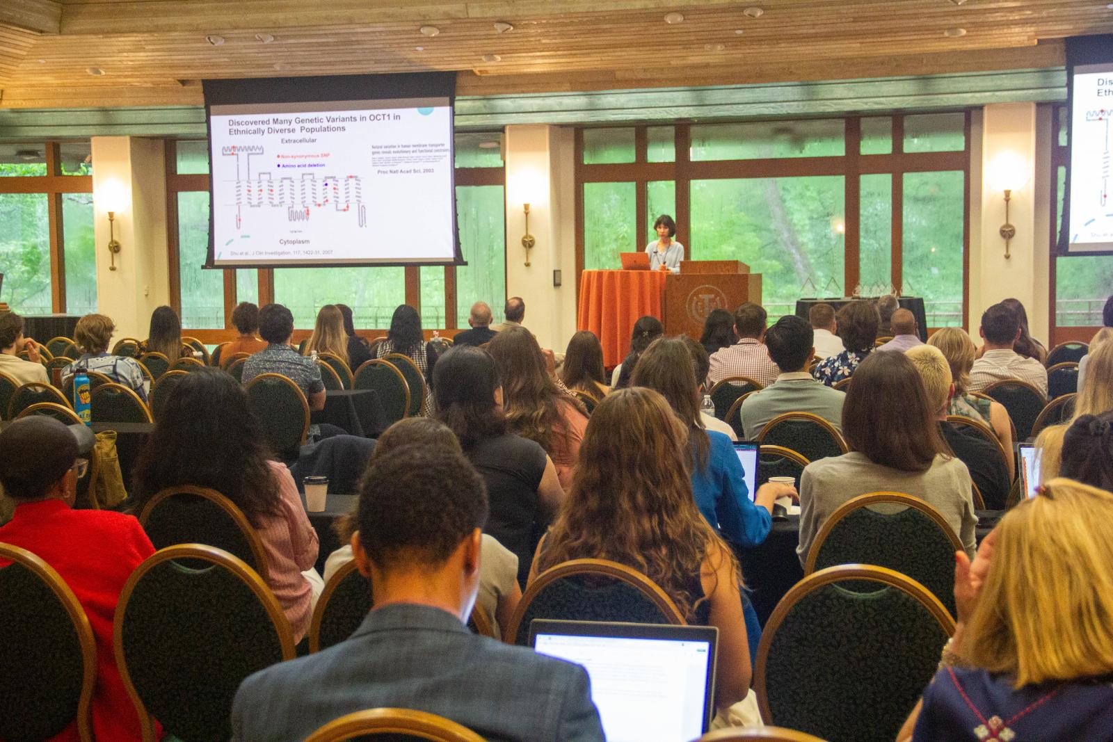 A woman giving a presentation in front of a lot of people.