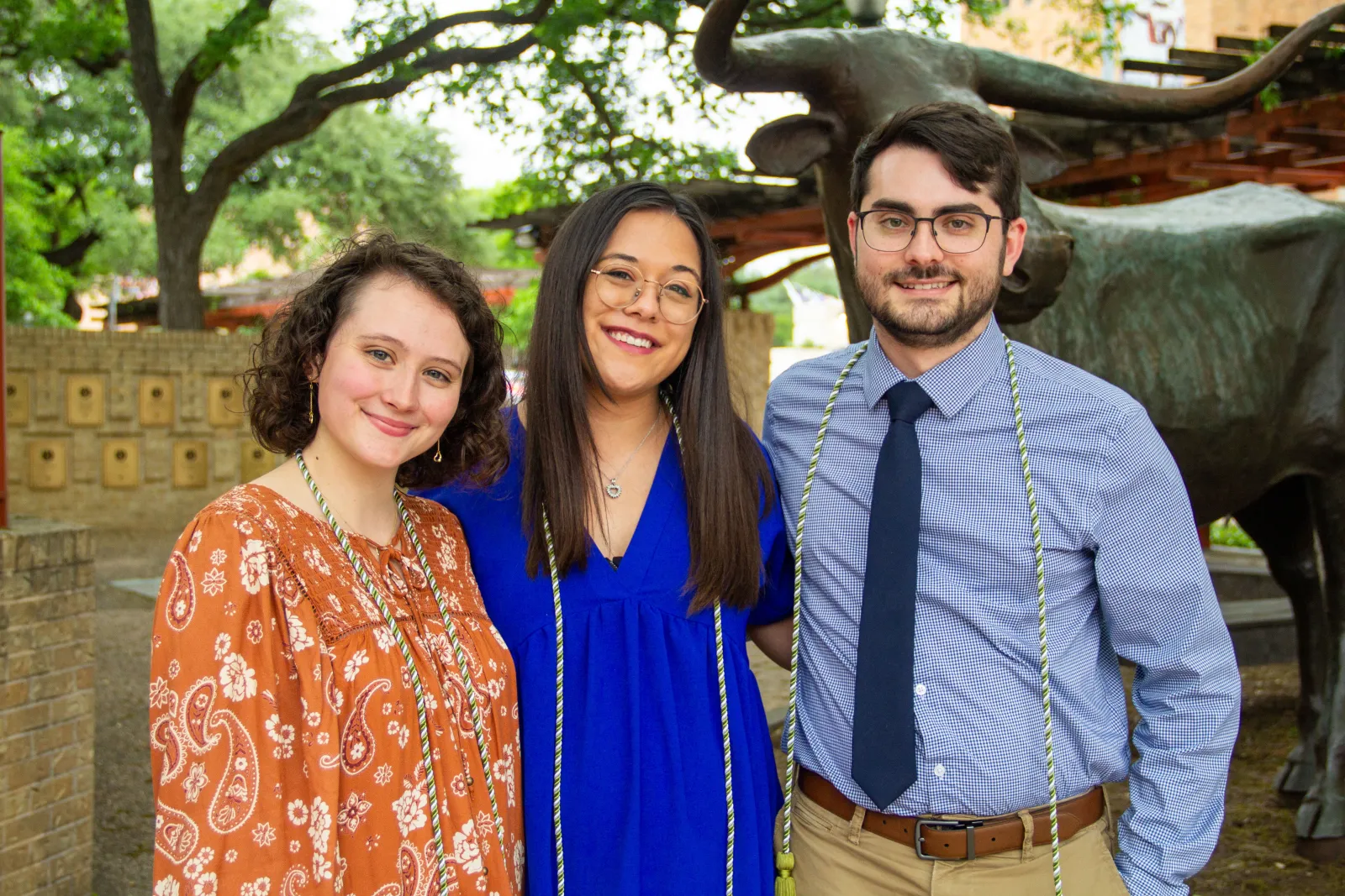 Three people smiling.