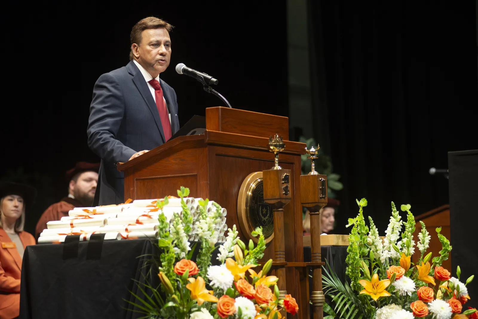 A man wearing a suit and giving a speech.