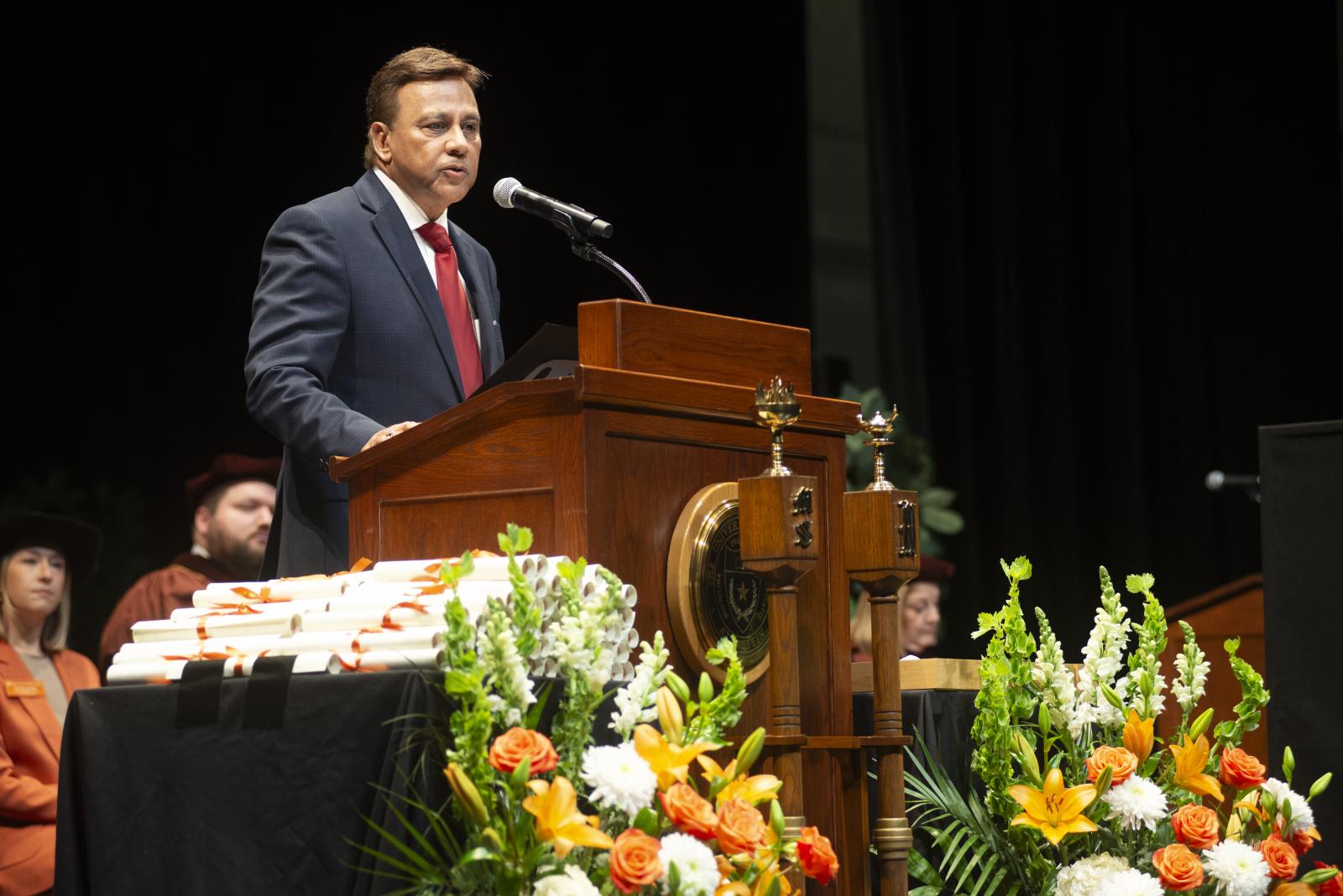 A man wearing a suit and giving a speech.