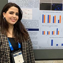 Maya Eldani standing in front of a research poster