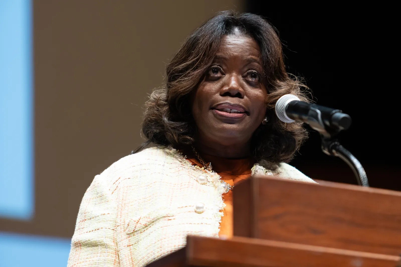 A woman giving a speech at a podium.