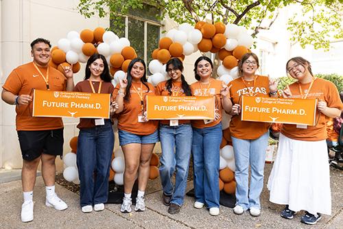 Seven incoming Pharm.D. students at the NSO block party holding up signs that say "Future Pharm.D."