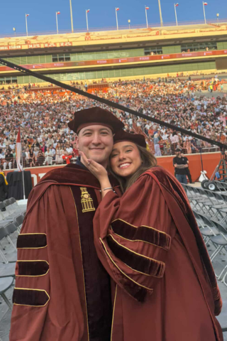 A photo of a Texas Pharmacy couple posing together at Commencement.