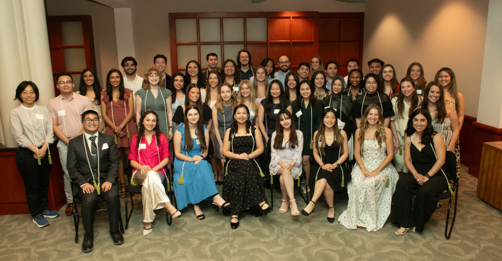 A group photo of Texas Pharmacy Honors Students, posing together indoors while wearing their honor cords. 