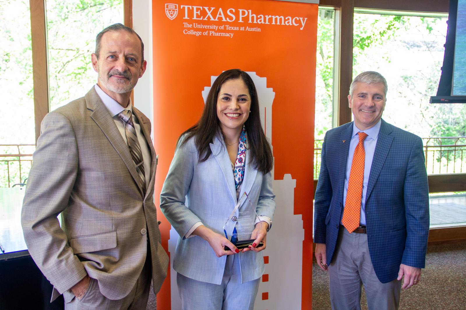 Two men presenting an award to a woman.