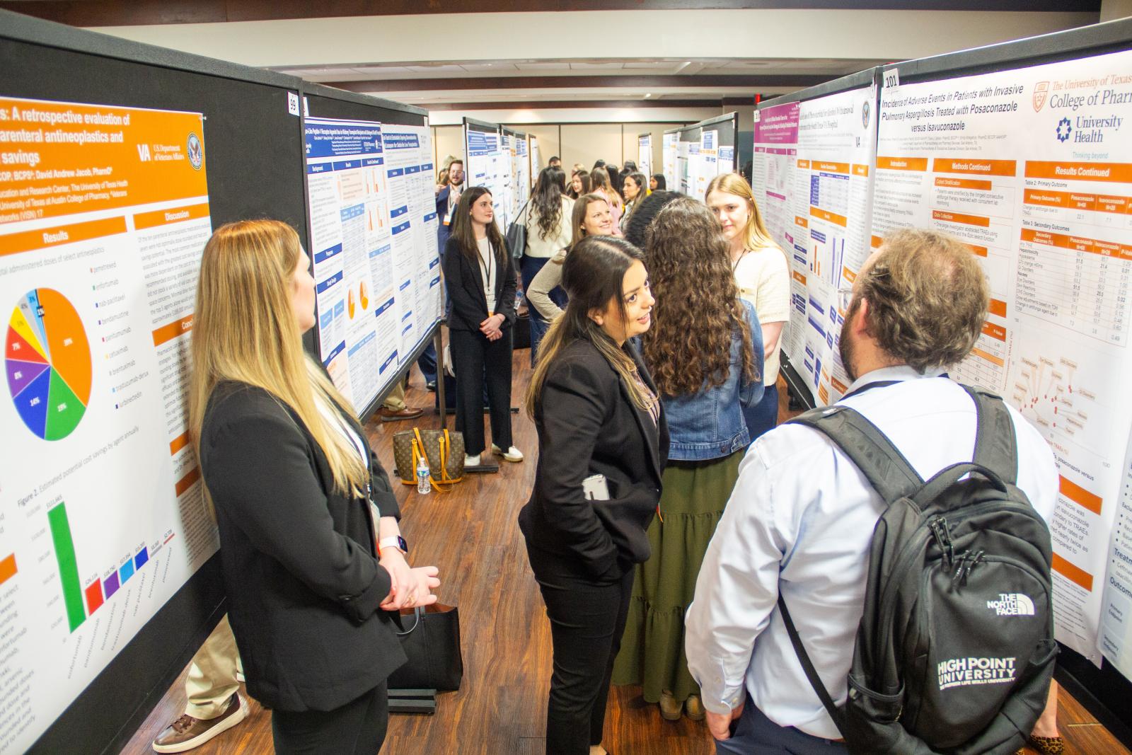 People in a hallway surrounded by research posters.