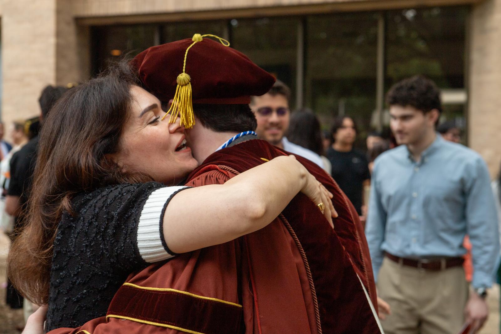 A graduate hugging a loved one.