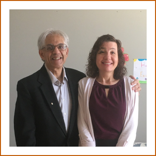 Drs. Kishor and Ellen Wasan pose warmly side by side, smiling brightly to camera.