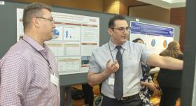 Two men in front of a research poster.