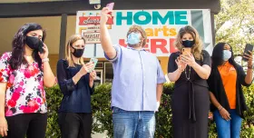 Five people holding cell phones and wearing masks.